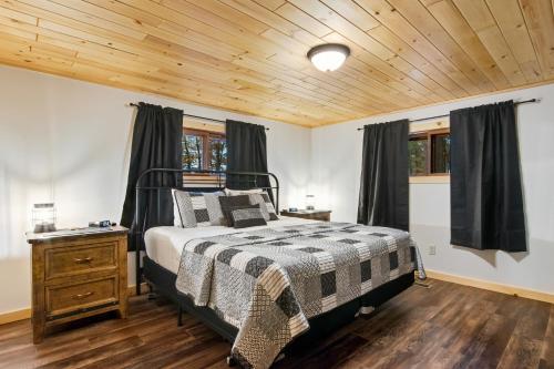 a bedroom with a bed and a wooden ceiling at The Lazy Bear in Saint Germain