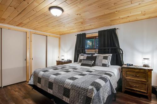 a bedroom with a bed and a wooden ceiling at The Lazy Bear in Saint Germain