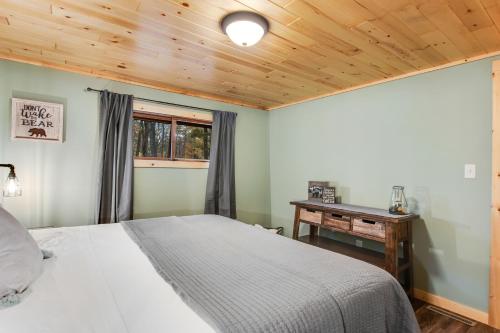 a bedroom with a bed and a wooden ceiling at The Lazy Bear in Saint Germain