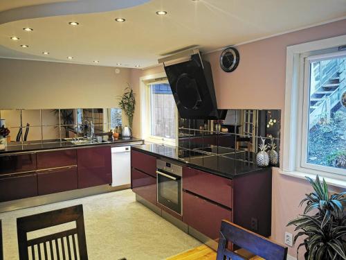 a kitchen with brown cabinets and a large window at Bergen Sunrise Terrace Apartment in Bergen