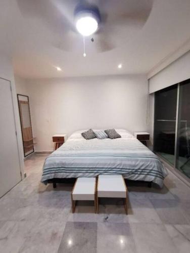 - une chambre avec un grand lit et 2 bancs dans l'établissement Condominio del faro frente a playa, à Nuevo Vallarta