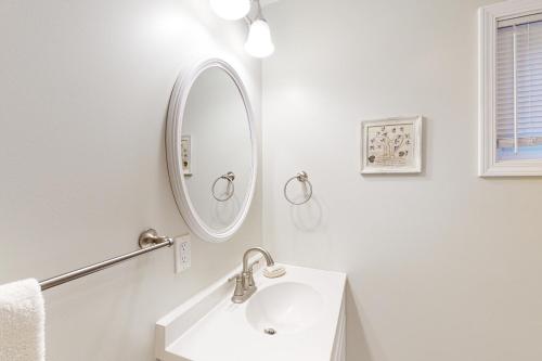 bagno bianco con lavandino e specchio di Bywater Bungalow a Empire