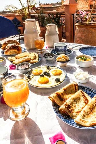 een tafel met borden met eten en drinken erop bij Riad Espoir, Riad de charme en exclusivité dans la médina de Marrakech in Marrakesh