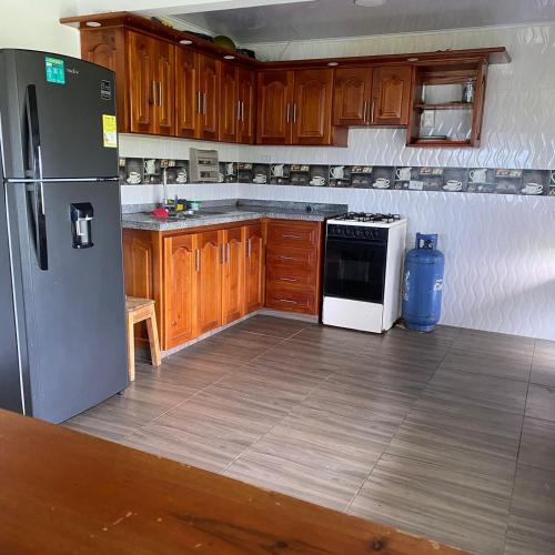 a kitchen with wooden cabinets and a stainless steel refrigerator at Finca Villa Anita Moniquirá Boyacá in Moniquirá