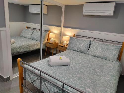 1 dormitorio con cama y espejo en Bedroom with Ensuite - Amazing Strand Location en Townsville