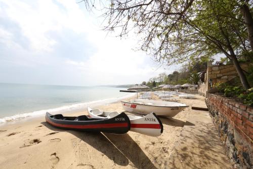 two boats are sitting on the sand on a beach at Sinop Antik Otel in Sinop