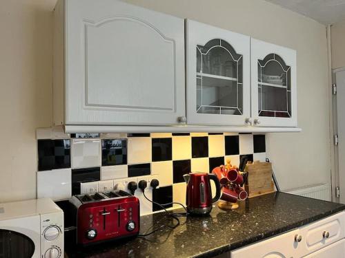 a kitchen with a black and white checkered wall at North Wales Holiday Accomodation with Free parking & WiFi in Bodelwyddan