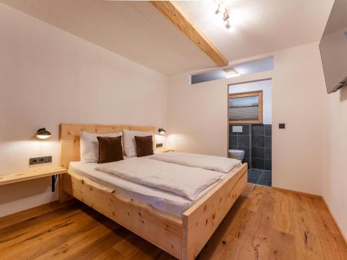 1 dormitorio con cama de madera y escritorio en AlmApARTment Mauterndorf Pichl 7-2, en Mauterndorf