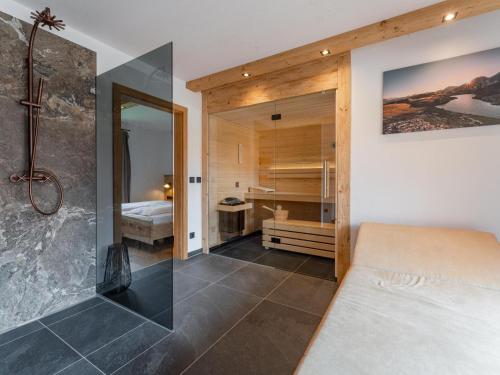 ein Schlafzimmer mit einem Bett und ein Badezimmer mit einer Dusche in der Unterkunft AlmApARTment Mauterndorf Pichl 8-1 in Mauterndorf