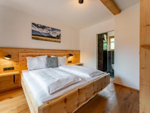 ein Schlafzimmer mit einem Holzbett in einem Zimmer in der Unterkunft AlmApARTment Mauterndorf Pichl 8-1 in Mauterndorf