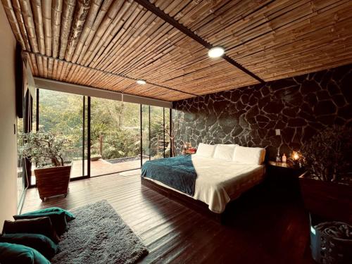 薩蘭托的住宿－Glamping Salento con jacuzzi climatizado，一间卧室设有一张床和石墙