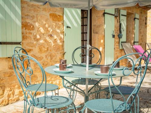 d'une table avec des chaises et des tasses. dans l'établissement Maison Sauveterre-la-Lémance, à Sauveterre-la-Lémance