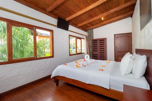 a bedroom with a bed with white sheets and windows at Napolitano Apart Hotel in Baños