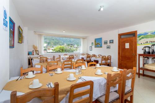 a dining room with tables and chairs and a window at Napolitano Apart Hotel in Baños