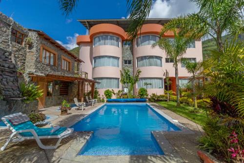 a hotel with a swimming pool in front of a building at Napolitano Apart Hotel in Baños