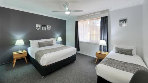 Ένα ή περισσότερα κρεβάτια σε δωμάτιο στο Colonial Motel & Apartments