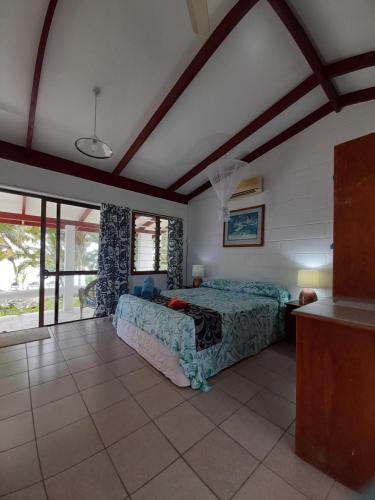 ein Schlafzimmer mit einem Bett in einem Zimmer in der Unterkunft Reefcomber Sunset Beach in Rarotonga