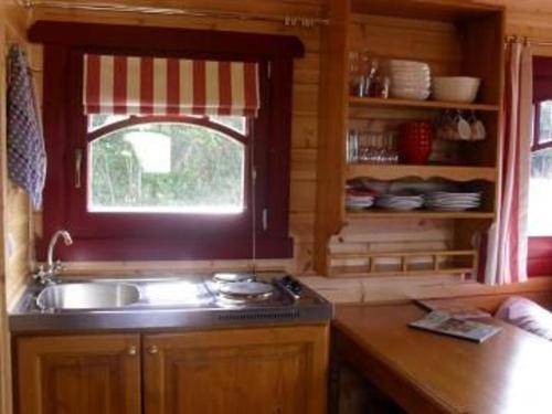 una cucina con un lavandino e una finestra di Séjour Bucolique en Roulotte au Cœur d'une Ferme Familiale en Sarthe - FR-1-410-229 a Chantenay-Villedieu