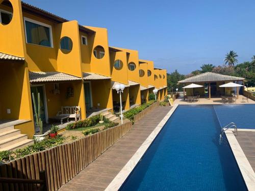 um resort com uma piscina ao lado de um edifício em Condomínio Imbassai Summer Flat em Imbassaí