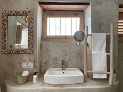 a bathroom with a white sink and a mirror at Sharazad Wonders Boutique in Zanzibar City
