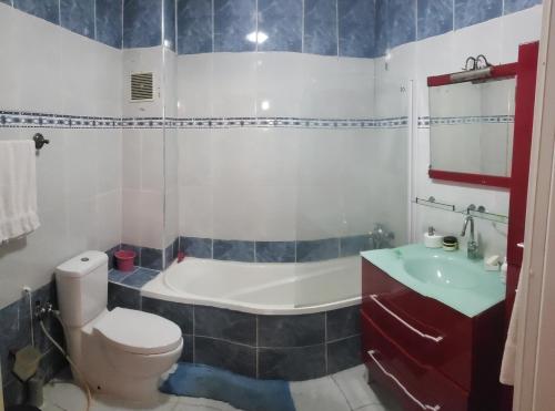 a bathroom with a tub and a toilet and a sink at Appartement meublé haut standing in Fez