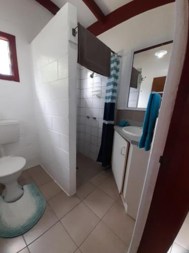 W łazience znajduje się umywalka, toaleta i lustro. w obiekcie Reefcomber Sunset Beach w mieście Rarotonga