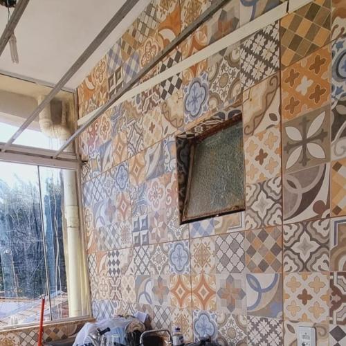 um quarto com uma parede em azulejo e uma janela em Apartamento completo em Guaratinguetá