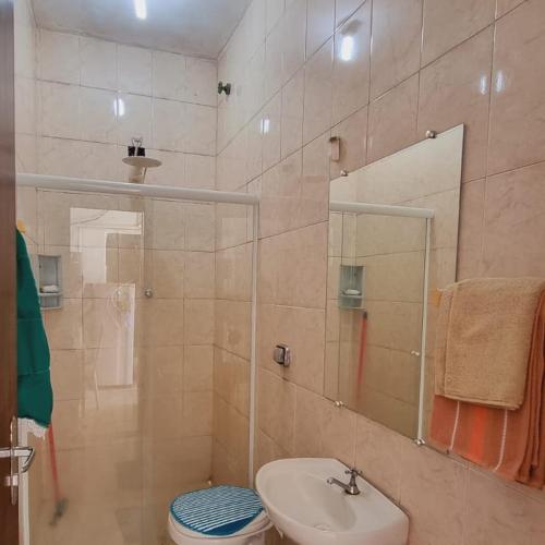 a bathroom with a sink and a toilet and a shower at Apartamento completo in Guaratinguetá