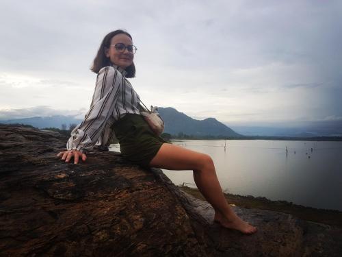 a woman sitting on a rock near a body of water at Moonshade Handapanagala in Monaragala