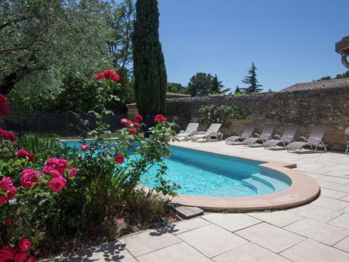una piscina con sillas y flores en un patio en Mansion in Fourn s with Private Pool, en Fournès