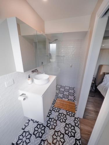 a white bathroom with a sink and a toilet at Coorparoo Comfort Apartment in Brisbane