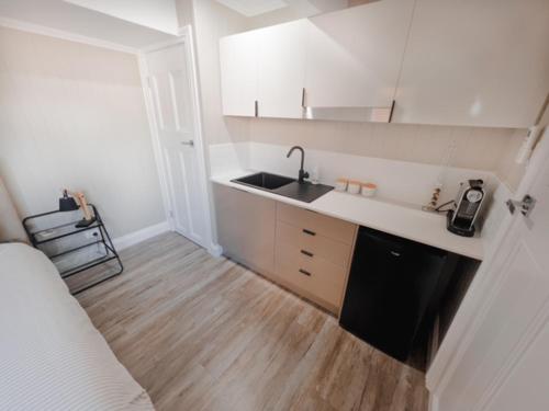 a small kitchen with a sink and a counter at Coorparoo Comfort Apartment in Brisbane