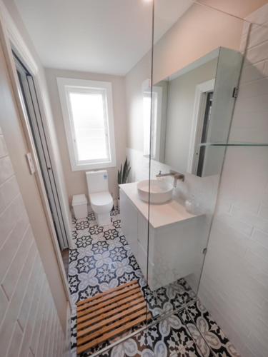 a bathroom with a sink and a toilet and a mirror at Coorparoo Comfort Apartment in Brisbane