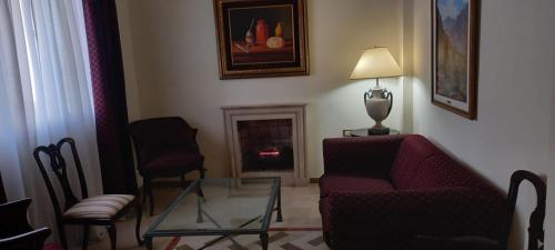 sala de estar con sofá, sillas y chimenea en HOSPEDAJE DEL PASEO en La Rioja