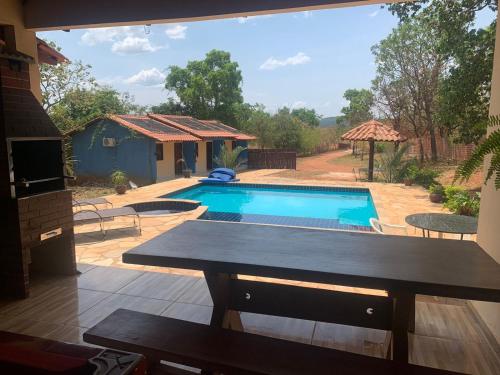 a swimming pool in a yard with a house at Chacara vila geovana suites in Pirenópolis