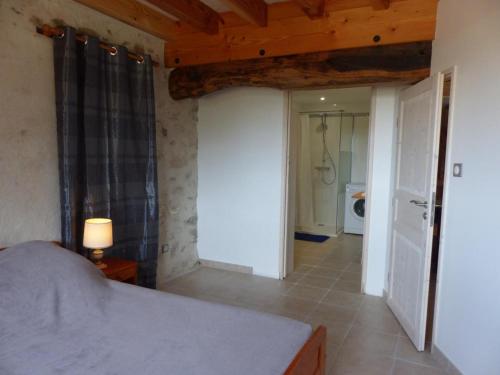 a bedroom with a bed and a hallway with a bathroom at Ferme éco-restaurée avec jardin, jeux enfants et parking près de Néris les Bains - FR-1-489-40 in Blomard