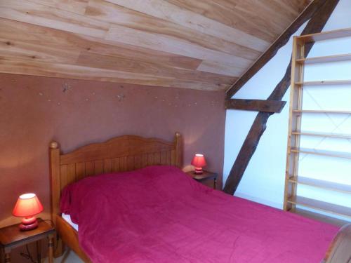 a bedroom with a bed with pink sheets and two lamps at Ferme éco-restaurée avec jardin, jeux enfants et parking près de Néris les Bains - FR-1-489-40 in Blomard