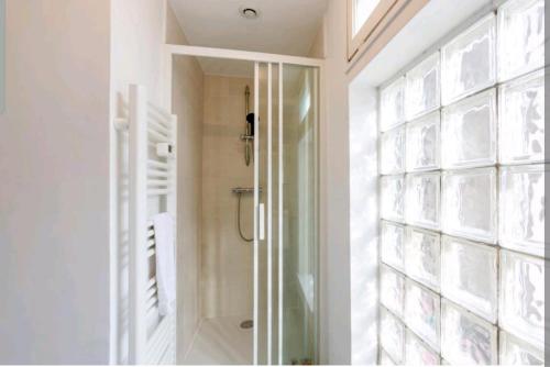 La salle de bains est pourvue d'une douche à l'italienne à côté d'une fenêtre. dans l'établissement Joli studio dans le centre ville de Brest, à Brest