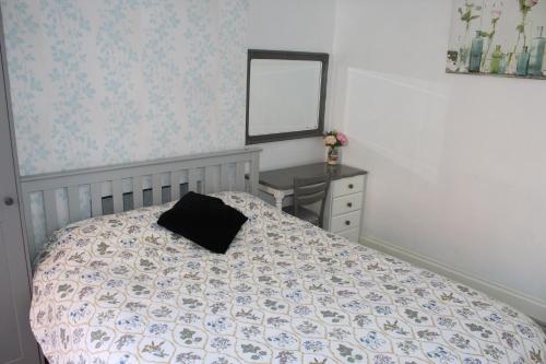 a bedroom with a bed and a mirror and a desk at U-DIN HOMES in Weymouth