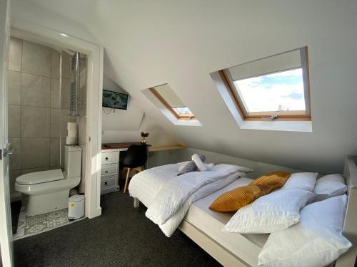 1 dormitorio con 2 camas y baño con ventana en Nice Living Serviced Accommodations 2 en Coventry