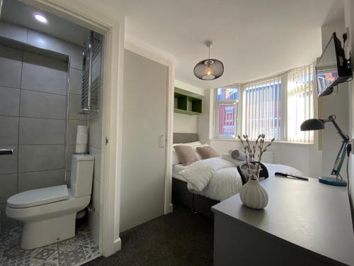 a bathroom with a bed and a toilet in a room at Nice Living Serviced Accommodations 2 in Coventry