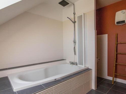 La salle de bains mansardée est pourvue d'une baignoire. dans l'établissement Villa in Port Blanc near Scenic Beaches, à Plougasnou