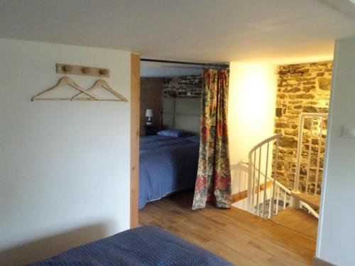 une chambre avec un lit et un mur en pierre dans l'établissement Terraced House in France near White Sand Beach, à Denneville