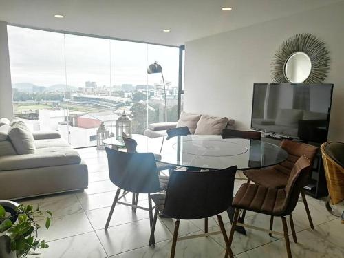 een woonkamer met een glazen tafel en stoelen bij Apartamento cerca de Centro CitiBanamex in Mexico-Stad