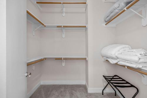 a walk in closet with white towels and a black chair at The Houston Villa - 2Qn+1King -MedCenter NRG ZOO in Houston
