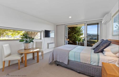 a bedroom with a bed and a table and a window at Apollo Blue Oceanview Unit 1- B Free WIFI in Apollo Bay