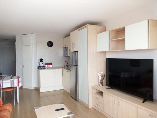 un salon avec une grande télévision à écran plat dans l'établissement Appartement pour 4 pers avec piscine et terrasse, parking privé, animaux acceptés - FR-1-379-152, à Vieux-Boucau-les-Bains