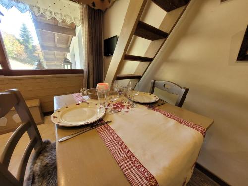 une table avec des assiettes et des verres au-dessus dans l'établissement Studio cocooning rénové avec parking et mezzanine - FR-1-598-113, aux Gets