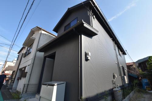a small building with a door on the side of it at PrimeRoom Beppu TATAMIsuite in Beppu