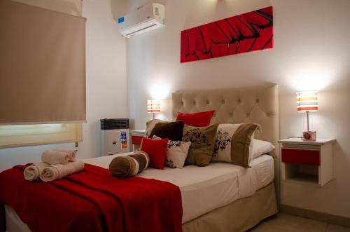 1 dormitorio con 1 cama blanca grande con almohadas rojas en 9 ¾ Apartamentos VIP en La Falda